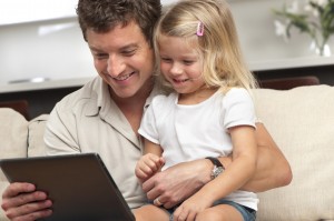 father and daughter looking at digital tablet